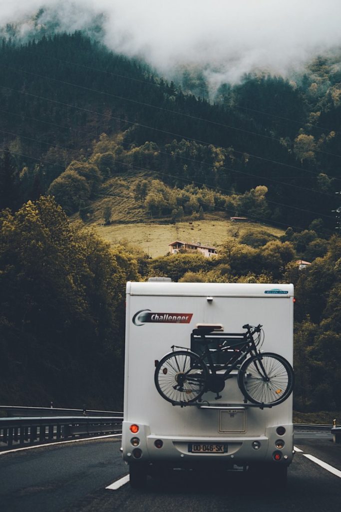 Wohnmobil fährt auf einer Straße auf ein Gebirge zu