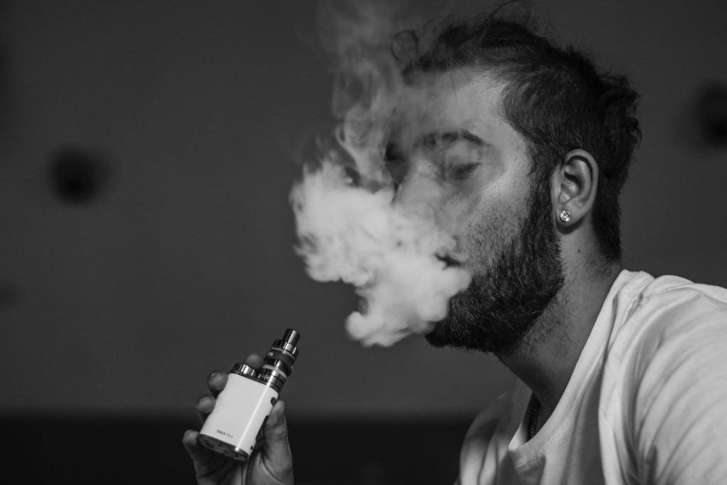 Mann dampft eine E-Zigarette