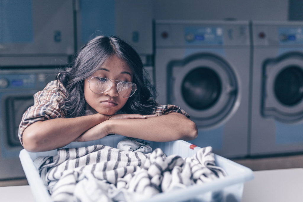 Junge Frau frustriert von nach Urin stinkender Wäsche